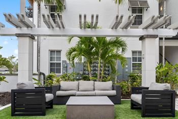 A patio with couches and a coffee table in front of a building
